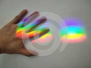 picture of hand on rainbow stripe on wall means seize beautiful dreams