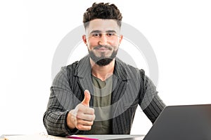 Picture of handsome young bearded man sitting over white wall background isolated