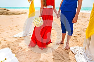 A picture of a happy couple holding hands at the beach. Newlyweds at the honeymoon. Close-up
