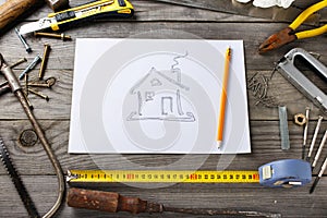 Picture of house on piece of paper with old tools
