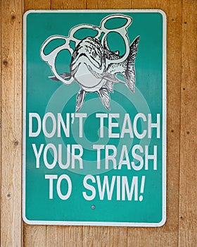 Humorous sign admonishing not to throw trash in the lake.