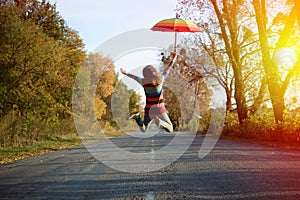 Picture of jumping lady holding umbrella with arms