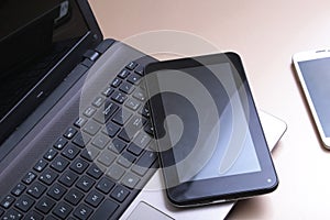 Picture of keyboard with a phone and tablet lying above it