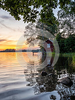 Picture of Lakeside Sunset with trees, scandinavian wooden house and blue sky