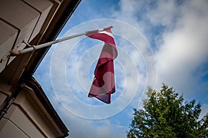 Selective blur on a latvian flag waiving in the sky in Riga. The flag of Latvia, or Latvijas karogs, is the national symbol of the photo