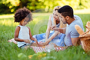 Picture of lovely couple with their daughter having picnic