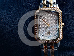 Picture of luxury woman wrist watch. Thus watch on a gold color and silver dial