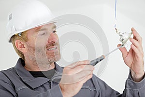 Picture male electrician installing hanging light