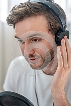 A picture of a man in black headphones speaking in microphone