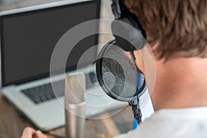 A picture of a man in black headphones speaking in microphone