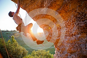 Picture of man clambering over rock.