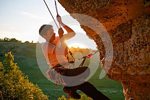 Picture of man clambering over rock.