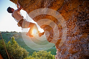 Picture of man clambering over rock.