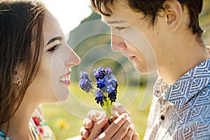 A picture of a man giving flowers to his lover on a summer day