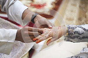 Picture of man putting wedding ring on woman hand