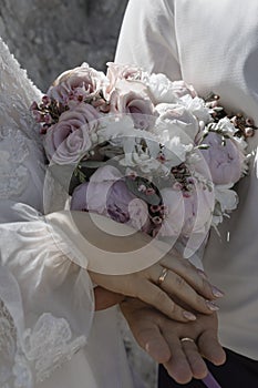 Picture of man and woman with bridal bouquet. Married couple holding hands, ceremony wedding day. Newly wed couple& x27;s