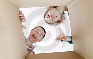 Picture of man and woman peering into cardboard box photo