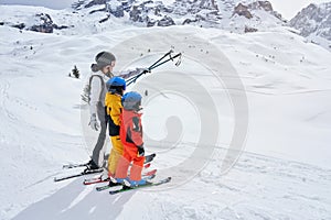 Picture of mother teach skiing her kids in Madonna di Campiglio