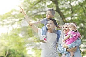 Muslim family looking at something in the park photo