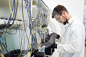 Picture of network technician testing modems in factory