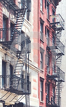 Picture of old buildings with fire escapes, color toning applied, New York City, USA