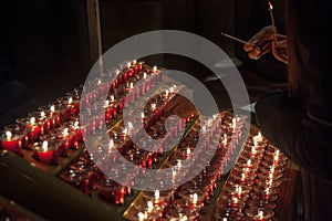 People lighting candles in the Notre Dame cathedral in Paris, France. Burning a candle is a usual practice in Catholicism