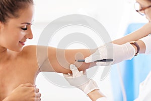 Plastic surgeon making marks on patient`s body