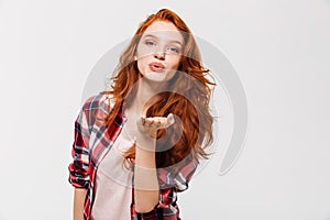 Picture of Pleased ginger woman in shirt sends air kiss