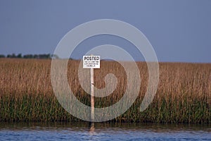 Picture of a posted sign in the marsh in South louisiana.