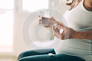 Picture of pregnant woman taking medication pills