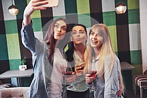 Picture presenting happy group of friends with red wine taking selfie