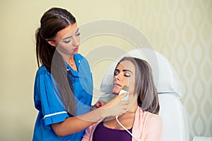 Picture of pretty beautician doing microdermabrasion procedure f