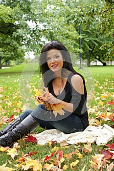 Picture of pretty woman holding leafs in the hands.