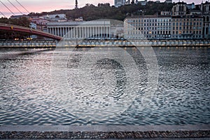 Panorama of the riverbank of Saone river in Lyon, France, at dusk, with Colline de Fourviere hill behind. photo