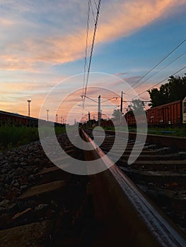 Picture of the  rail road and train rails running to the horizon and freight wagons.