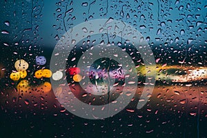 Picture Raindrops on glass window against blurred city lights background