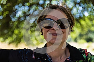 Picture of a relaxed attractive woman in the shadows of a tree