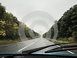 Picture of the road, taken from the windshield from the car. Road drive trip in autumn at rainy weather. Traveling in the car