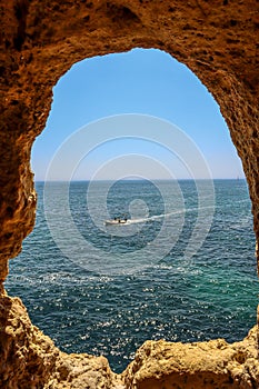 Rock window with a view of a boat in Algar Seco, Portugal photo