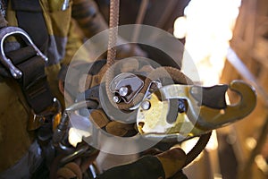 Picture of rope access male hand opening descender and clipping connecting inserting with 10 MM low stretch Nylon abseiling rope photo