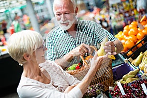 Picture of senior couple at marketplace buying vegetables