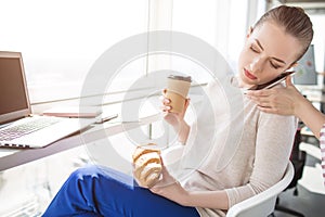 A picture of serious busainess woman talking on the phone. Somebody helps her to hold the phone in right position. Girl