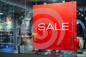 Picture of shop window display with text Sale on red poster. Shopping Sale background.