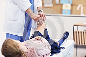 Little girl in clinic having a checkup with orthopaedist photo