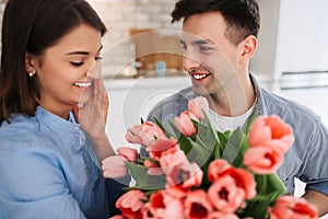 Picture showing man giving flowers to a woman at home. Romantic concept. Woman`s day