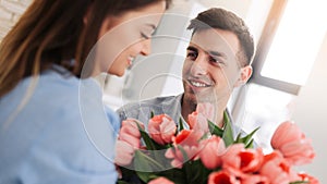 Picture showing man giving flowers to a woman at home. Romantic concept. Woman`s day photo