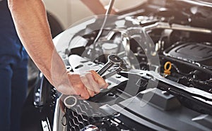 Picture showing muscular car service worker repairing vehicle