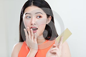 Picture showing smart attractive young asian girl holding credit card with happiness and joyful.