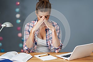 Tired female student learning till late at home