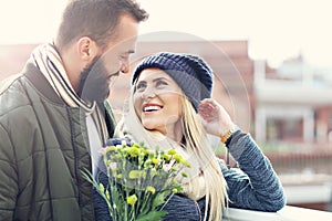 Picture showing young couple with flowers dating in the city